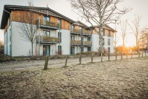 a large building with a fence in front of it at Am Park 24 in Prerow +6 photos