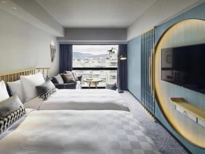 a hotel room with two beds and a flat screen tv at Mercure Kyoto Station in Kyoto