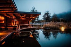 a log cabin with a pond in front of it at Spa Camping Schwarzwälder Hof in Seelbach