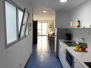a kitchen with white cabinets and blue tile floors at Numancia 1 - 4A in Las Palmas de Gran Canaria