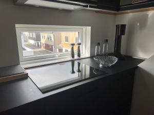 a kitchen counter with a window with wine bottles on it at Penthouse Apartment with Balcony in City Centre and Private Parking in Tórshavn +18 photos