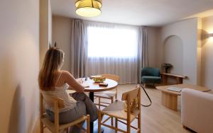 a woman sitting at a table in a room at Alcudia Boutique Apartments in Alcudia +46 photos