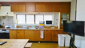 a kitchen with wooden cabinets and a flat screen tv at さつき邸 -Satsuki House- in Fukuoka +42 photos