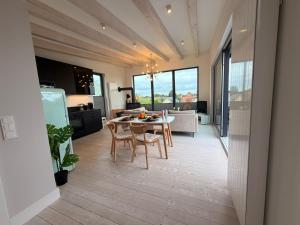a kitchen and dining room with a table and chairs at Lilla Villa - Pá stranden - in Kellenhusen