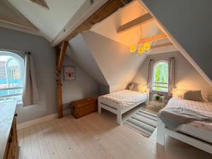 a attic bedroom with two beds and a window at Lilla Villa - Pá stranden - in Kellenhusen