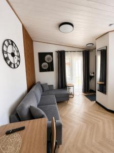 a living room with a couch and a clock on the wall at Pärnu Summer Studio in Pärnu