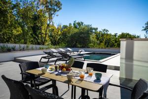 a patio with a table and chairs and a swimming pool at My Dalmatia - Sea View Villa Senti with private pool in Starigrad +78 photos