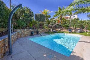 a swimming pool in a yard with a brick wall at Villa avec piscine au soleil d'Azur in Fréjus