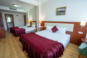 a hotel room with two beds with red sheets at La Garden Hotel Old City in Istanbul +57 photos