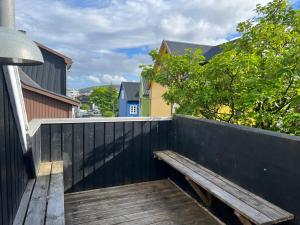 a wooden bench sitting on a wooden deck at Penthouse Apartment with Balcony in City Centre and Private Parking in Tórshavn