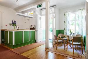 a dining room with a green table and chairs at Kanalvillan Dalsland in Dals Långed +30 photos