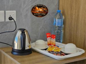 a coffeemaker sitting on top of a table with a tea kettle at WADI RUM JULIA lUXURY CAMP in Wadi Rum
