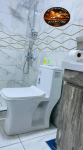 a bathroom with a white toilet in a room at WADI RUM JULIA lUXURY CAMP in Wadi Rum +77 photos