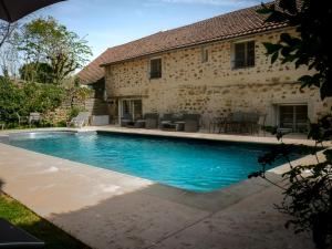 a swimming pool in front of a house at Clos De La Gourmandière, Maison d'hôtes & Restaurant in Saint-Lothain