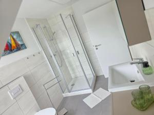 a bathroom with a shower and a toilet and a sink at Ferienwohnung Rückerts Gartenblick in Nordhausen +15 photos