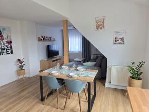 a dining room and living room with a table and chairs at Ferienwohnung Rückerts Gartenblick in Nordhausen