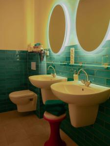 a bathroom with two sinks and a toilet and mirrors at Das Wilde 70er in Dobritz