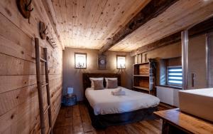 a bedroom with a bed in a room with wooden walls at Les Gîtes de Sprimont - Le Cosy in Sprimont +55 photos