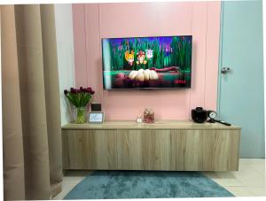 a living room with a tv on a pink wall at 2BR Unit at Hill Residences I Free Parking in Manila