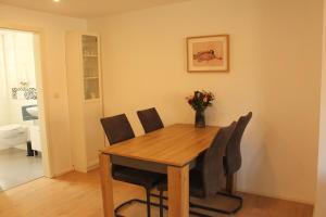 a dining room table with chairs and a vase of flowers at Ferienwohnung "Lüttje Koje" in Barßel