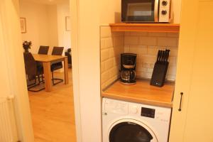 a kitchen with a microwave and a washing machine at Ferienwohnung "Lüttje Koje" in Barßel