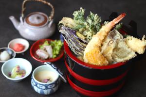 a red and black bucket of food with corn and dips at Yumoto Koganeyu in Jozankei