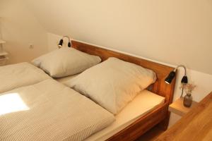 a bed with two pillows on it in a room at Ferienwohnung "Lüttje Koje" in Barßel