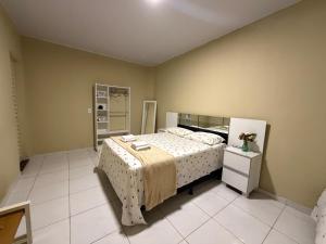a bedroom with a large bed and a mirror at Casa mobiliada AR01 com 5 camas e 2 quartos in Juazeiro do Norte