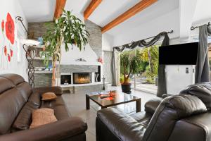 a living room with leather furniture and a fireplace at Maison avec piscine Soleil d'Azur in Fréjus