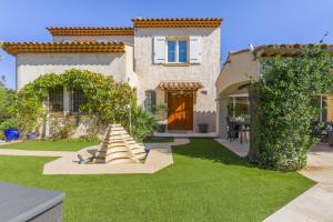 a house with a yard with green grass at Maison avec piscine Soleil d'Azur in Fréjus