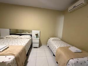 two beds sitting in a room with at Casa mobiliada AR01 com 5 camas e 2 quartos in Juazeiro do Norte
