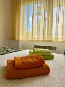 two towels on top of a bed with a window at WISH Apartment Sarajevo in Sarajevo