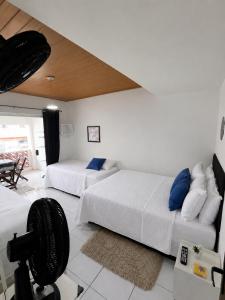 a bedroom with two beds and a camera in it at Mandalas Guest House in Cabo Frio