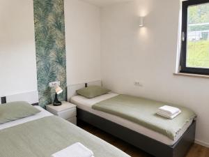 two twin beds in a room with a window at Apartma Lilly in Bohinjska Bela +26 photos