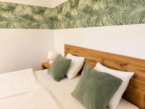 a bedroom with a bed with two green and white pillows at Apartma Lilly in Bohinjska Bela