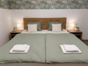 a bedroom with a large bed with two towels on it at Apartma Lilly in Bohinjska Bela