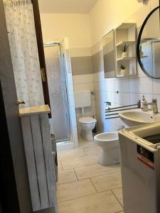 a bathroom with a toilet and a sink and a shower at Casa Merella in Narbolia