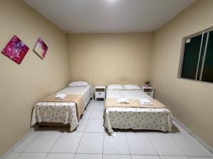 a room with two beds and a window at Casa mobiliada AR01 com 5 camas e 2 quartos in Juazeiro do Norte