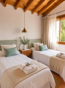 a bedroom with two beds and a window at LA CUMBRE-Calma, Desconexión y Piscinas Naturales en Sierra de Gata TR-CC-00490 in Gata