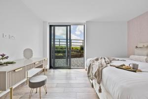 a bedroom with a bed and a desk with a chair at The Retreat at Strashleigh Manor Farm - A Luxury Devon Country Escape in Ivybridge