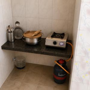 a kitchen counter with a pot and a stove at G R MANSION in Vellore