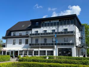 a large white building with a black roof at Appartement Briesenick-Radde in Tossens