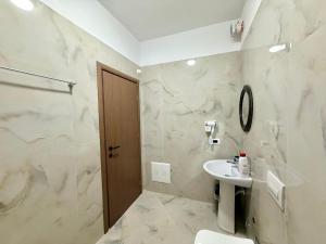 a bathroom with a sink and a toilet and a mirror at Actium in Vlorë +113 photos