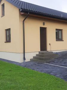 a house with a door and stairs in front of it at Agroturystyka u Pauliny in Sąpów