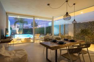 a living room with a table and a pool at Villa D'Argento in Ragusa