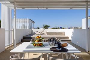 a table with a bowl of fruit on a balcony at Villa D'Argento in Ragusa