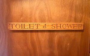 a sign on a wooden door that reads toilet shower at Newtonmore Hostel in Newtonmore