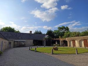 a barn with a grassy yard next to a building at Maison de charme en pierre in Morville
