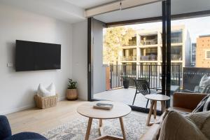 a living room with a couch and a tv at The Ellery in Newcastle