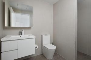 a white bathroom with a toilet and a sink at The Ellery in Newcastle +11 photos